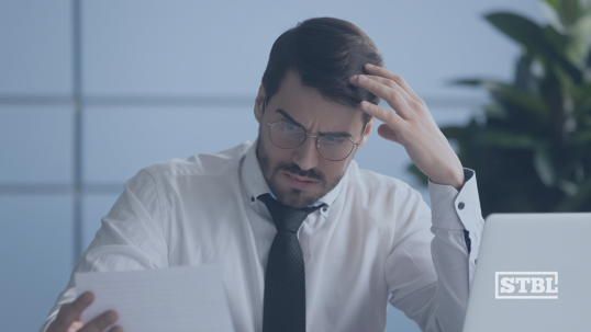 Concerned business owner reviewing documents.