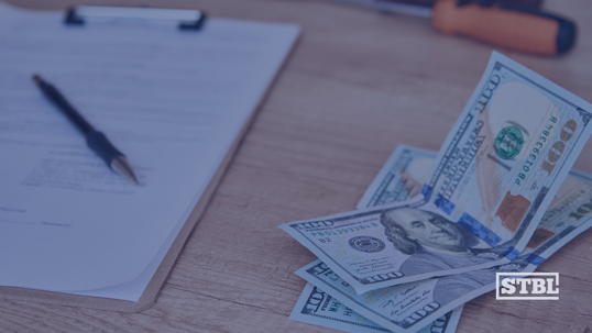 Money for selling a business next to document needing to be signed.